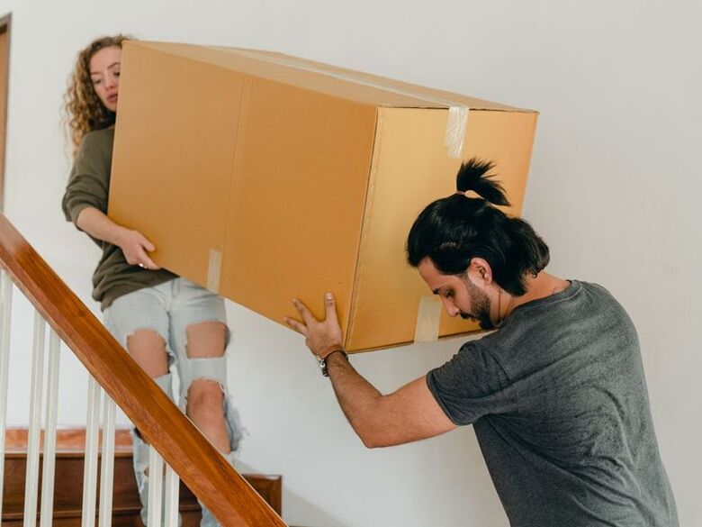 Last Mile Moving crew carrying boxes into a downtown Denver loft building